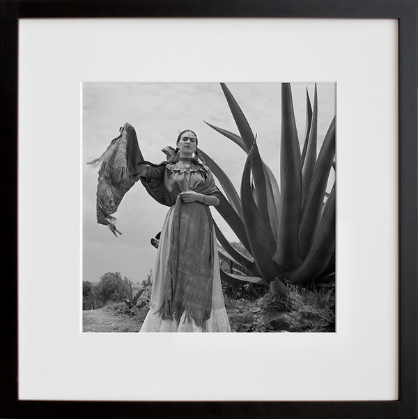 Frida Kahlo standing next to an agave plant