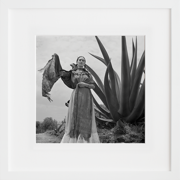 Frida Kahlo standing next to an agave plant