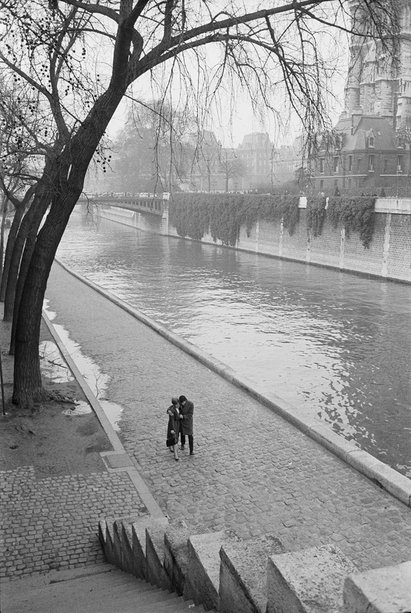 A couple walking along the Seine River in Paris