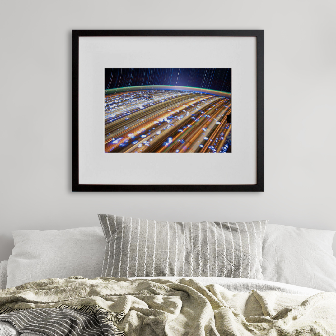 jsc2012e052676: star trails over Earth's city lights, in a black frame on a wall