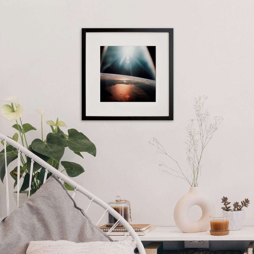 AS07-08-1933: the sun over Earth's horizon, photographed from Apollo 7, in a black frame on a wall
