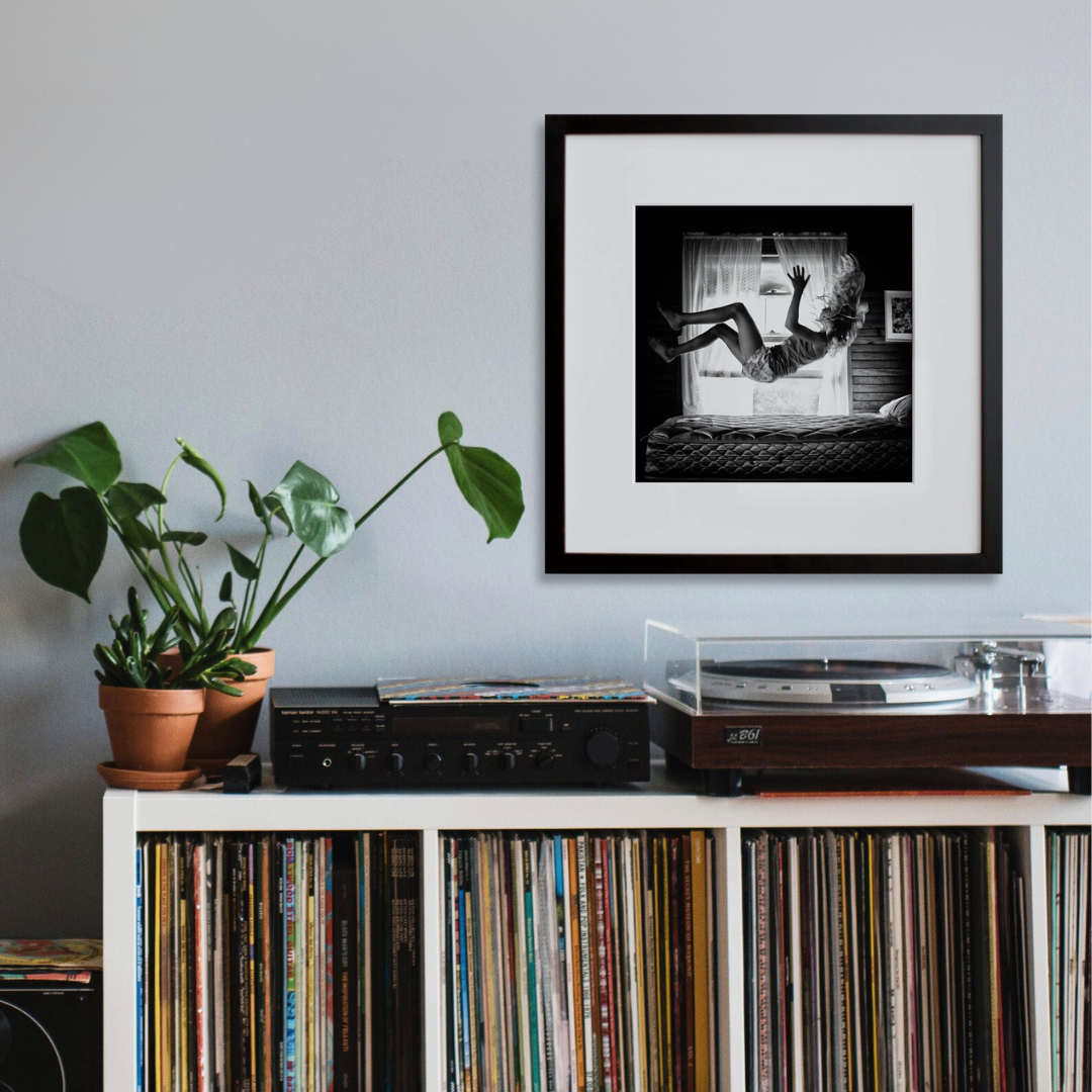 Lolie, Jumping on the Bed, 2013 in a black frame on a wall