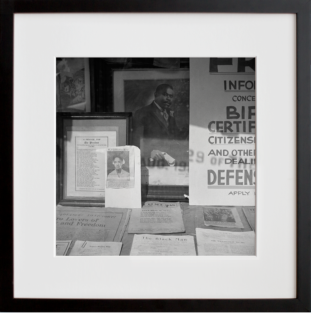 Signs in the windows of a Marcus Garvey club in the Harlem area in a black frame