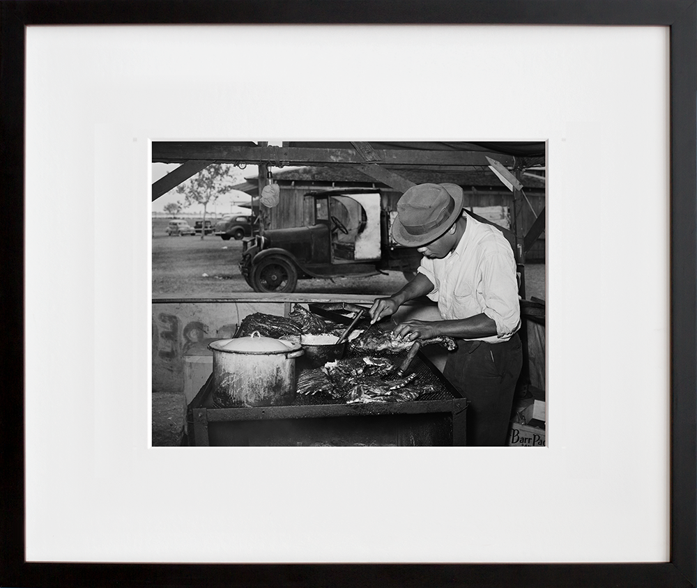 Man slicing barbecue at the Gonzales County Fair in a black frame