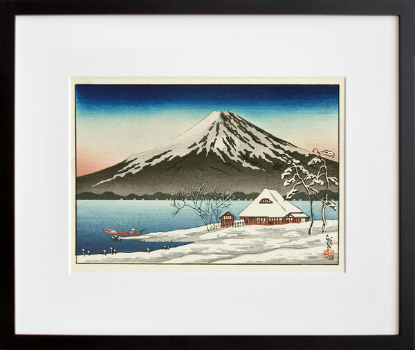 Winter landscape with small snow-covered building on the coast and view of Mount Fuji