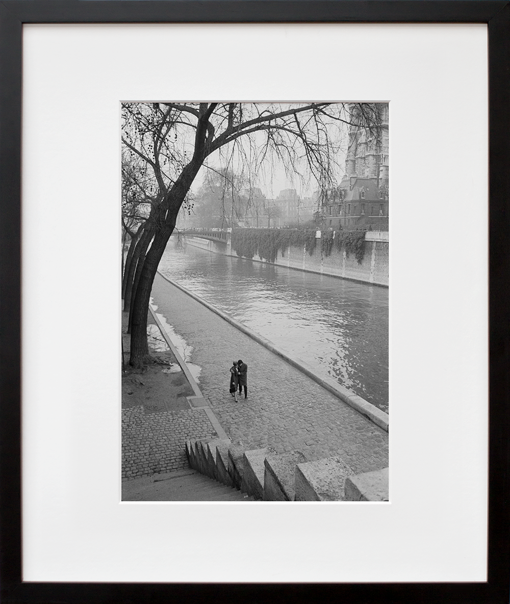 A couple walking along the Seine River in Paris in a black frame