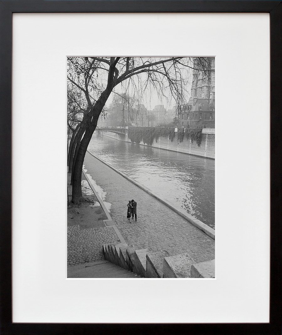 A couple walking along the Seine River in Paris