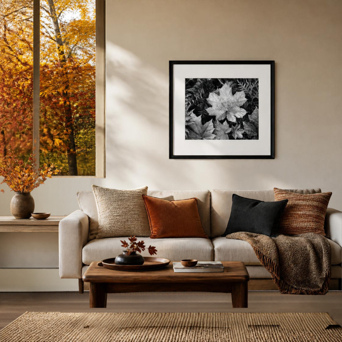 Ansel Adams' black-and-white leaf print framed above a sofa in an autumn living room